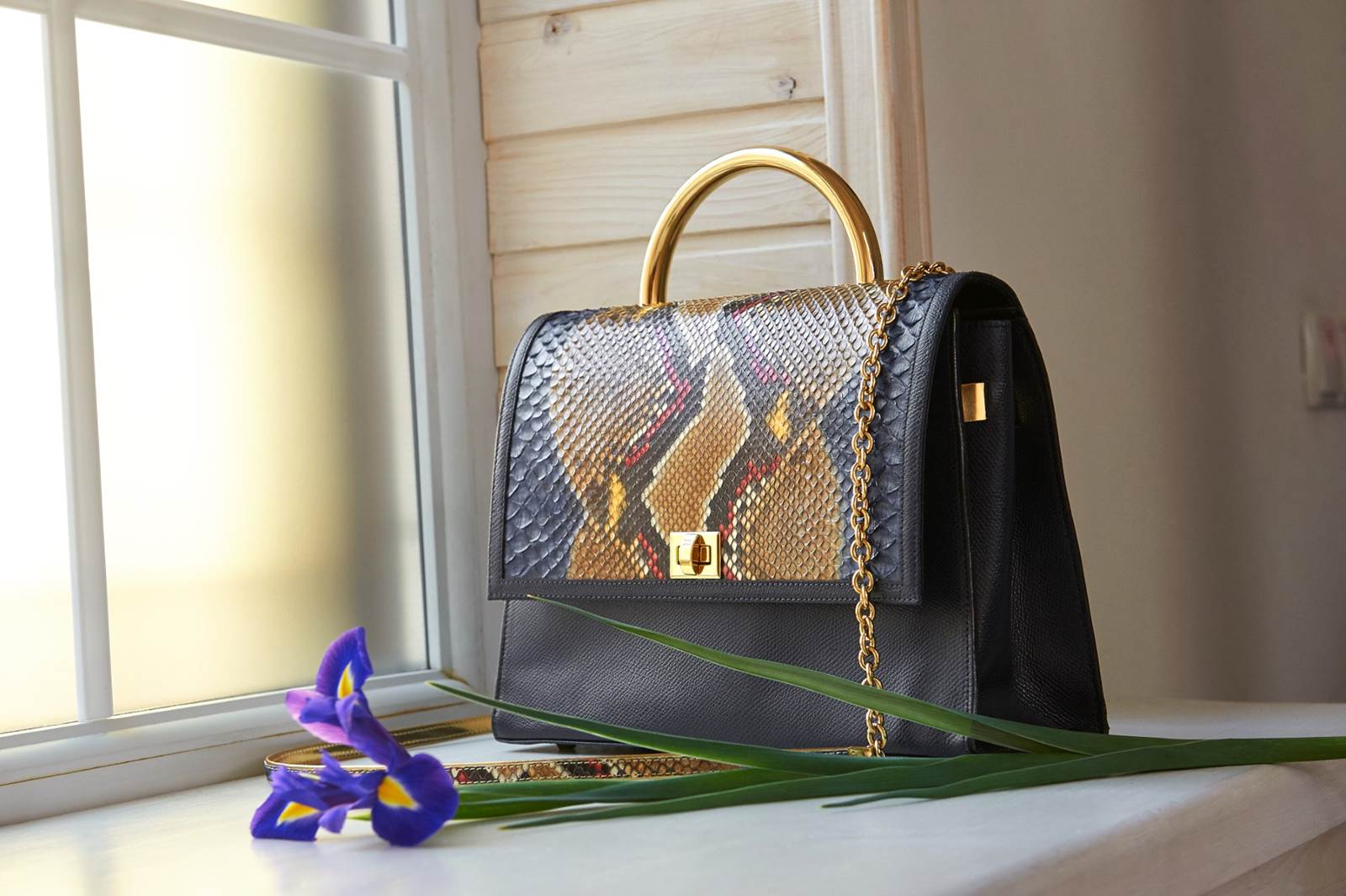 Elegante y moderna mujer con bolso junto a la ventana
