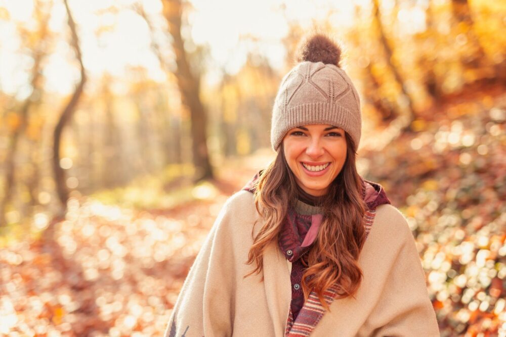 Mujer caminando por el bosque en un soleado día de otoño