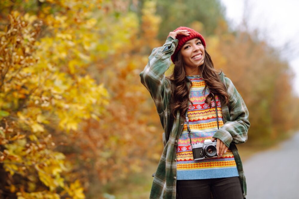 Hermosa joven es fotografiada con una cámara retro. Concepto de descanso, relajación, viaje y estilo de vida
